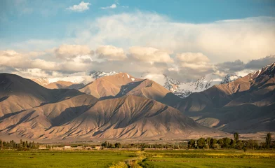 Foto op Canvas Beautiful scenic shot of fields and the Tian Shan Mountains in Kyrgyzstan. © Wollwerth Imagery