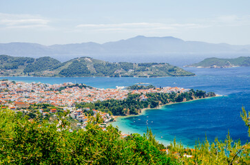 Fototapeta na wymiar Aerial view of Skiathos old town, Sporades, Greece. Beautiful panoramic landscape of aegean vivid sea and beach from above. Visit greek island for summer holiday travel.