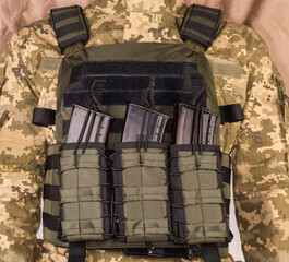 Military bulletproof vest with pouches with magazines dressed on soldier