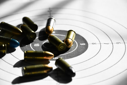 9mm bullets and 9mm bullet case on shooting target paper, soft and selective focus.