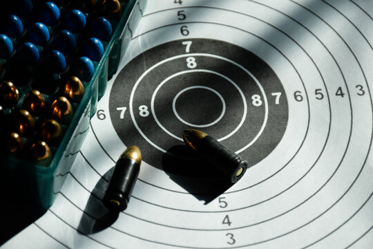9mm bullets and 9mm bullet case on shooting target paper, soft and selective focus.