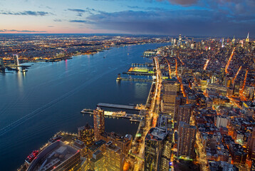 Aerial view of New York city and New Jersey illuminated at dusk with Hudson River - Powered by Adobe