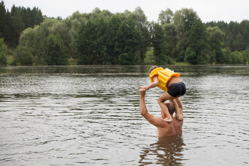 Family on vacation splashing in a lake. Kid boy jumping in outdoor in a lake. Happy grandparents...