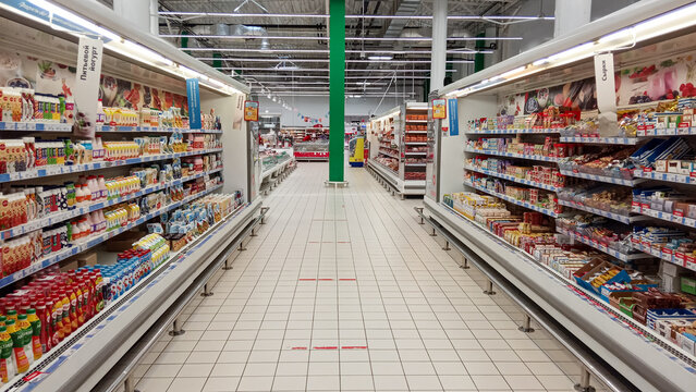 Hypermarket Auchan. Shopping center. Shelves are filled with packaged dairy products. Milk products from Russian and Belarusian manufacturers in huge quantities. Krasnodar, Russia - 01 June 2022