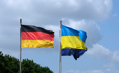 The flags of Ukraine, Germany, and the EU waving in the wind