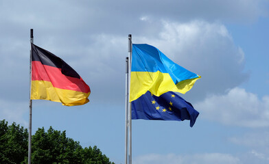 The flags of Ukraine, Germany, and the EU waving in the wind