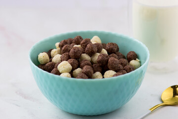 Breakfast cereal close-up. Bowl of corn flakes on a white marble table