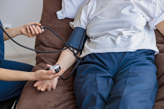 Close up of nurse checking blood pressure of woman in the ward of modern clinic. High quality photo