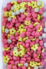 Corn snacks in the shape of hearts, flowers and balloons close-up. Quick breakfast cereal