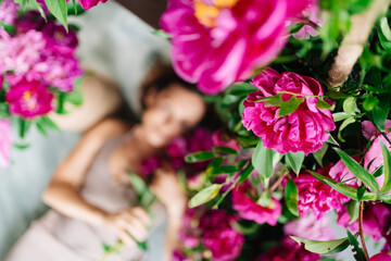 focus on flowers. an attractive woman on the floor with a bouquet of peonies.