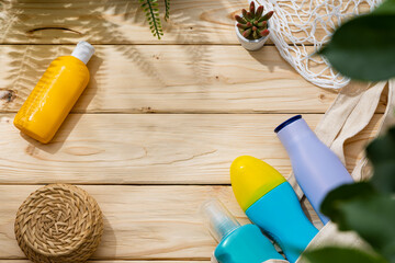 Sunscreen cream bottles in beach bag on wooden background