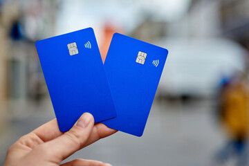 Bank cards are close-up against the background of a blurred street. Chip and contactless payment in...