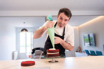A challenger man cooking a red velvet cake at home, assembling the triple sponge base of the cake...