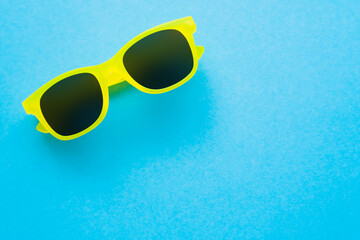 Top view of sunglasses on blue background.