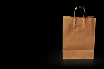 Brown paper bag insulated on a black background, front view. Delivery service advertisement.