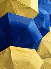 close up of stacks of folding umbrellas made of blue and yellow parachute cloth in an open state