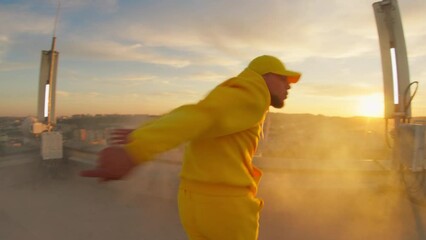 Closeup b-boy dancer dancing breakdown freestyle street dance choreography moves and playing on wide-angle camera. First-person view. Sunset performance. Rooftop.
