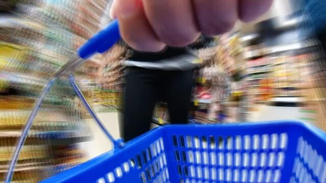 Motion timelapse of shopping cart moving around the supermarket between stands with goods, hyperlapse.