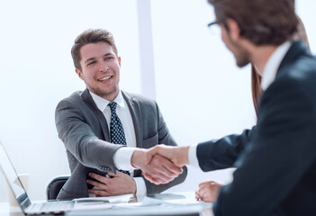 smiling businessman shaking hands with his business partner .