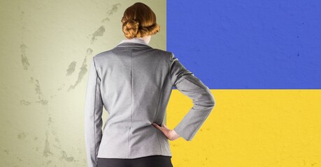 Rear view of caucasian businesswoman against ukraine flag design background - Powered by Adobe