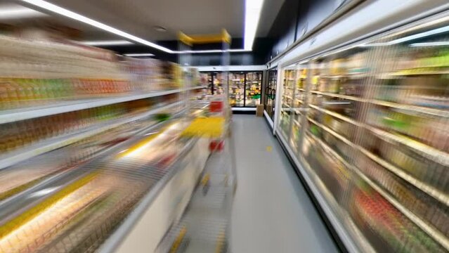 Motion timelapse of shopping cart moving around the supermarket between stands with goods, hyperlapse.