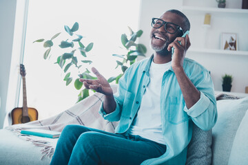 Photo of cheery laughing middle aged man enjoying conversation with best friend tell funny joke spend free time at home