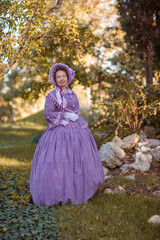 Fototapeta premium Woman in victorian dress walking in the park. Vintage fashion.
