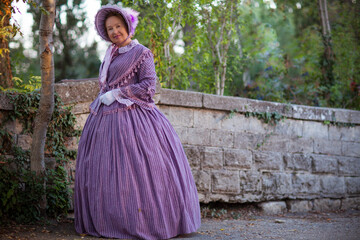 Fototapeta premium Woman in victorian dress walking in the park. Vintage fashion.