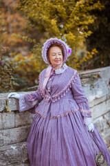 Woman in victorian dress walking in the park. Vintage fashion.