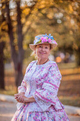 Woman in victorian dress walking in the park. Vintage fashion.