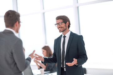 businessman talking with a colleague standing in the office