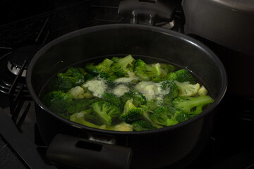 cooked broccoli on a metal platter, or black pan. healthy eating concept.