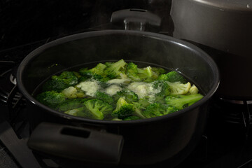 cooked broccoli on a metal platter, or black pan. healthy eating concept.