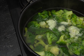 Cooked brocolli on steam in a bowl