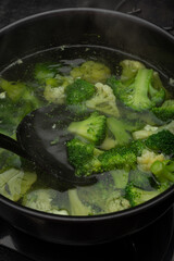 Cooked brocolli on steam in a bowl