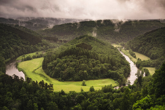Tombeau du G&eacute;ant on a rainy summer day in South Belgium, with green pine forest and Semois river on a cloudy sky