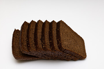 evenly cut pieces of black bread lie on a white background