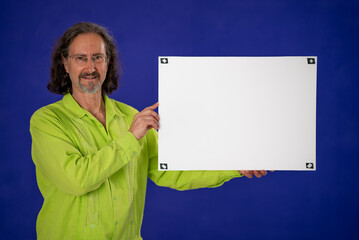 Happy businessman giving pointing to and holding empty blank white placard showing copy space with tracking points on green screen chroma key background. - Powered by Adobe