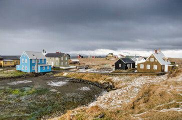 Flatey, Iceland, May 5, 2022: the dark clouds of a recent snow storm still loom over the village...