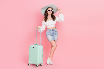 Fototapeta na wymiar Full length photo of adorable good mood lady waiting her flight in airport isolated on pink color background