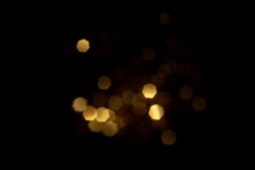 Golden blurred bokeh lights on black background. Glitter sparkle stars for celebrate. Overlay for your design
