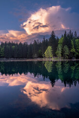 Vivid clouds at sunset by Fusine lake