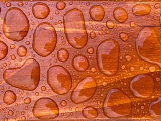water drops on a brown wood surface