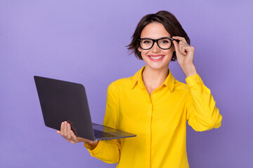 Photo of nice young lady hold laptop wear yellow outfit eyewear isolated on violet color background