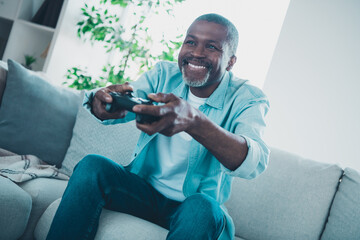 Photo of cheerful good mood mature gamer addicted to play playstation spend free weekend time indoors