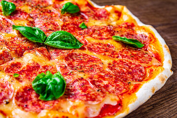 Pepperoni Pizza with Mozzarella cheese, salami, Tomatoes, pepper, Spices and Fresh Basil. Italian pizza