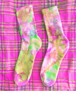 bright multicolored socks are hand painted. they lie on a checkered background. fashion photo
