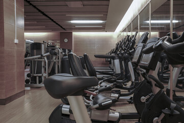 Modern light gym. Sports equipment in gym. Barbells of different weight on rack.	
