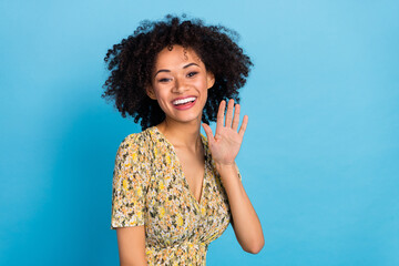 Portrait of attractive cheerful wavy-haired girl waving hi hello isolated over vibrant blue color background © deagreez