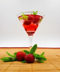 Summer drink with raspberry, strawberry and mint in a glass. Refreshing drink with fruit.